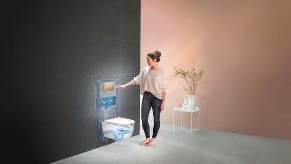 Naine Geberiti WC-süsteemi loputust aktiveerimas (© Geberit)